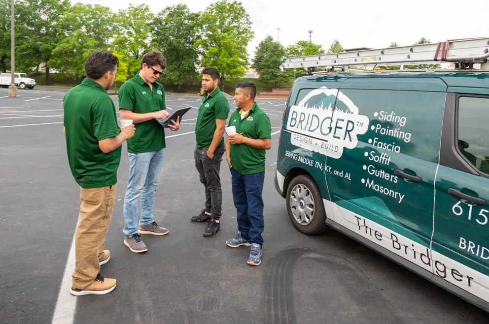 Bridger Design + Build siding team discussing a project on-site